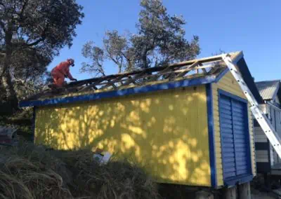 On the beach we restored the roof of a yellow and blue beach box